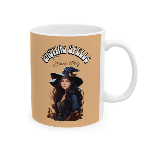 Mug with a beautiful brunette witch design, autumn leaves and a retro aesthetic text 'Casting Spells Since 1980s' on a beige background
