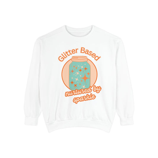 White sweatshirt with orange and mint colored  graphic design of a jar filled with glitter and retro style text on a white background