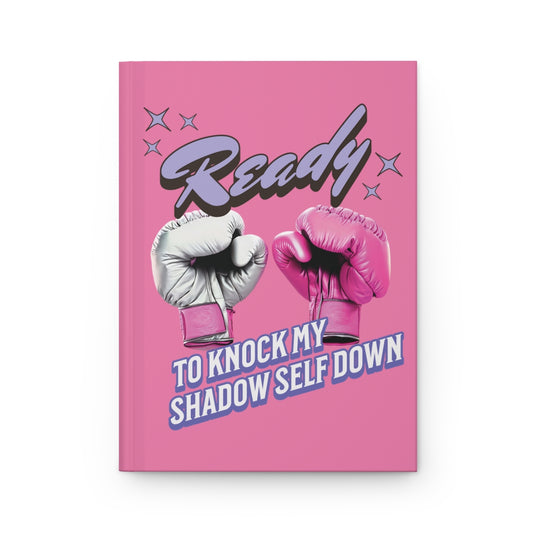 Pink journal featuring pink boxing gloves design and a retro aesthetic pastel purple text  "ready to knock my shadow self down" with graphic design of retro purple stars