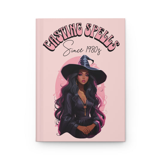 Pastel pink Journal with an Illustration of a beautiful witch girl with retro groovy aesthetic text 'Casting Spells Since 1980s' 